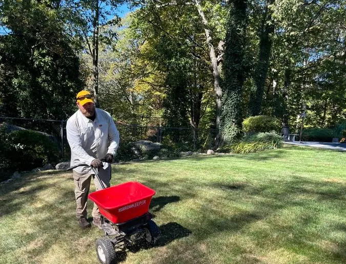 Pops Pest Control team applying lawn fertilizer treatment