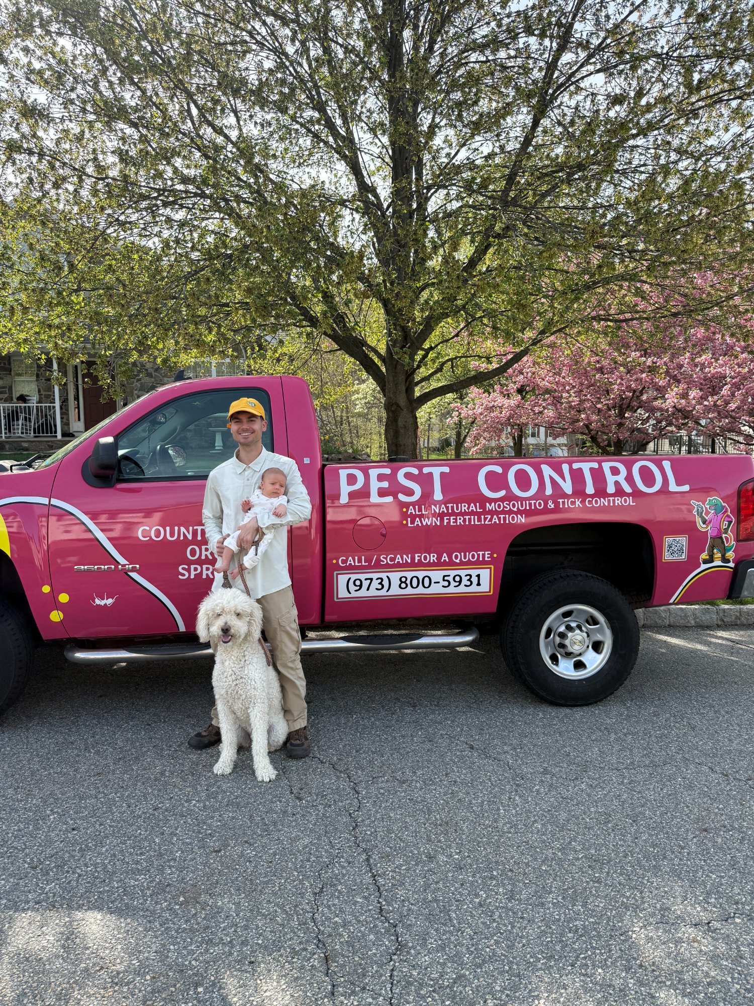 Pops Pest Control owner with newborn and dog in front of service truck